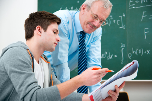 Teacher and student looking over homework