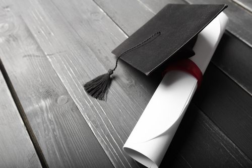 Master's degree diploma and graduation cap